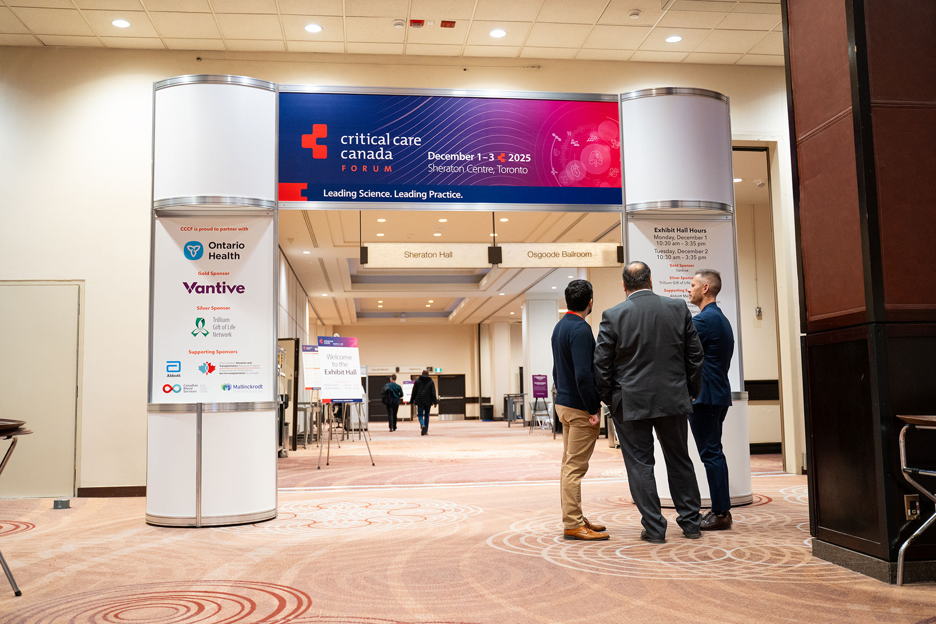Conference entrance with metal frame and fabric panels displaying Critical Care Canada Forum signage in blue and red